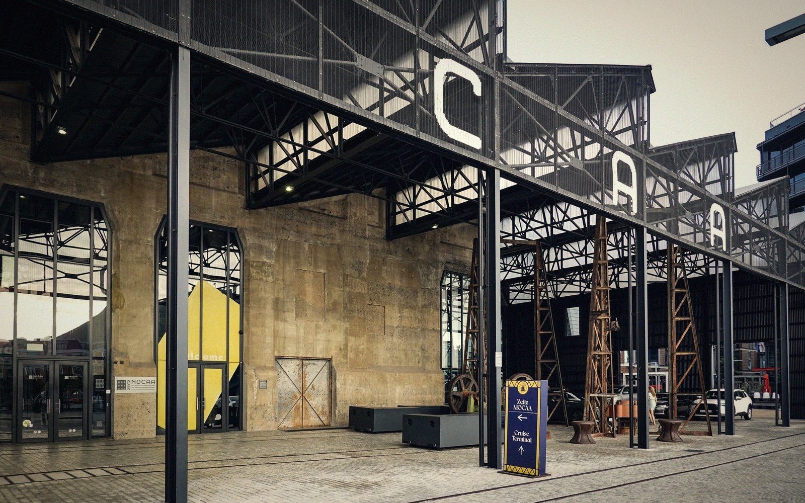 Converted power plant building with steel gantry framing and large lettering above the entrance